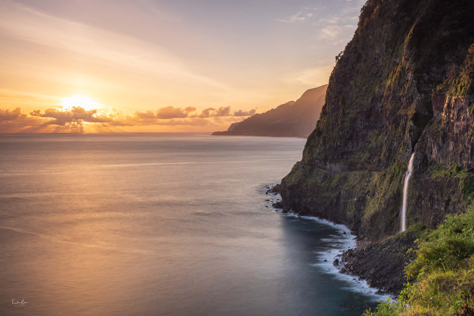 Ein Wasserfall aus einem Felsen. In madeira zur goldenen Stunde am Morgen nach Sonnenaufgang fotografiert