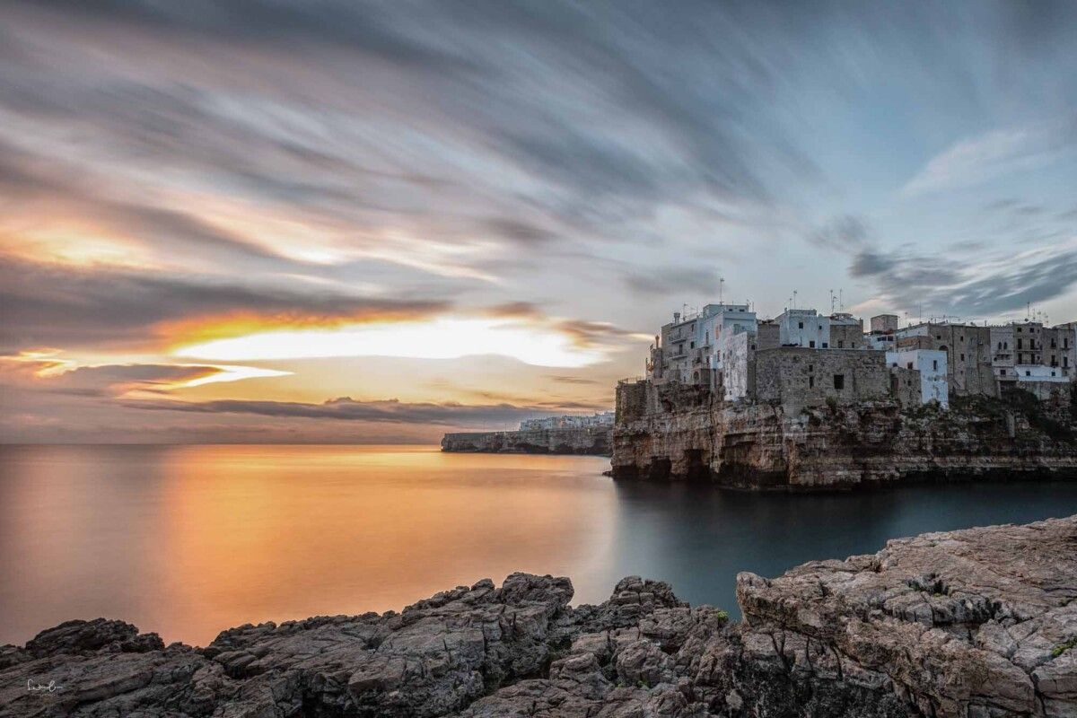 Polignano a Mare zum Sonnenaufgang mit ziehenden Wolken